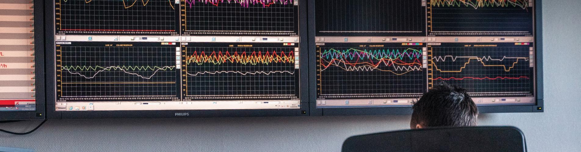 Photo d'un agent RESE devant les écrans de supervision de la production d'eau potable