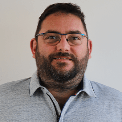 Photo d'identité d'un homme blanc bien en chair aux cheveux courts bruns légèrement barbu portant des lunettes