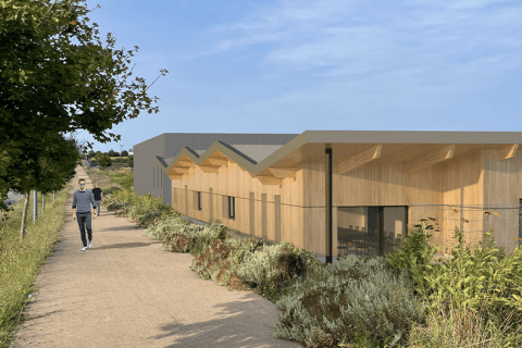 Vue d'architecte de l'agence Saintonge Romane en construction qui présente la façade du bâtiment sur un niveau d'aspect bois depuis le cheminement piétonnier situé devant