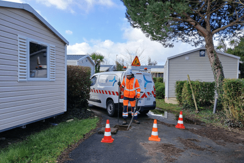 Photo montrant un agent de la RESE réalisant un contrôle de conformité des raccordements des mobiles d'un camping au réseau d'assainissement collectif